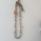 Necklace with circular pendants on a plain background