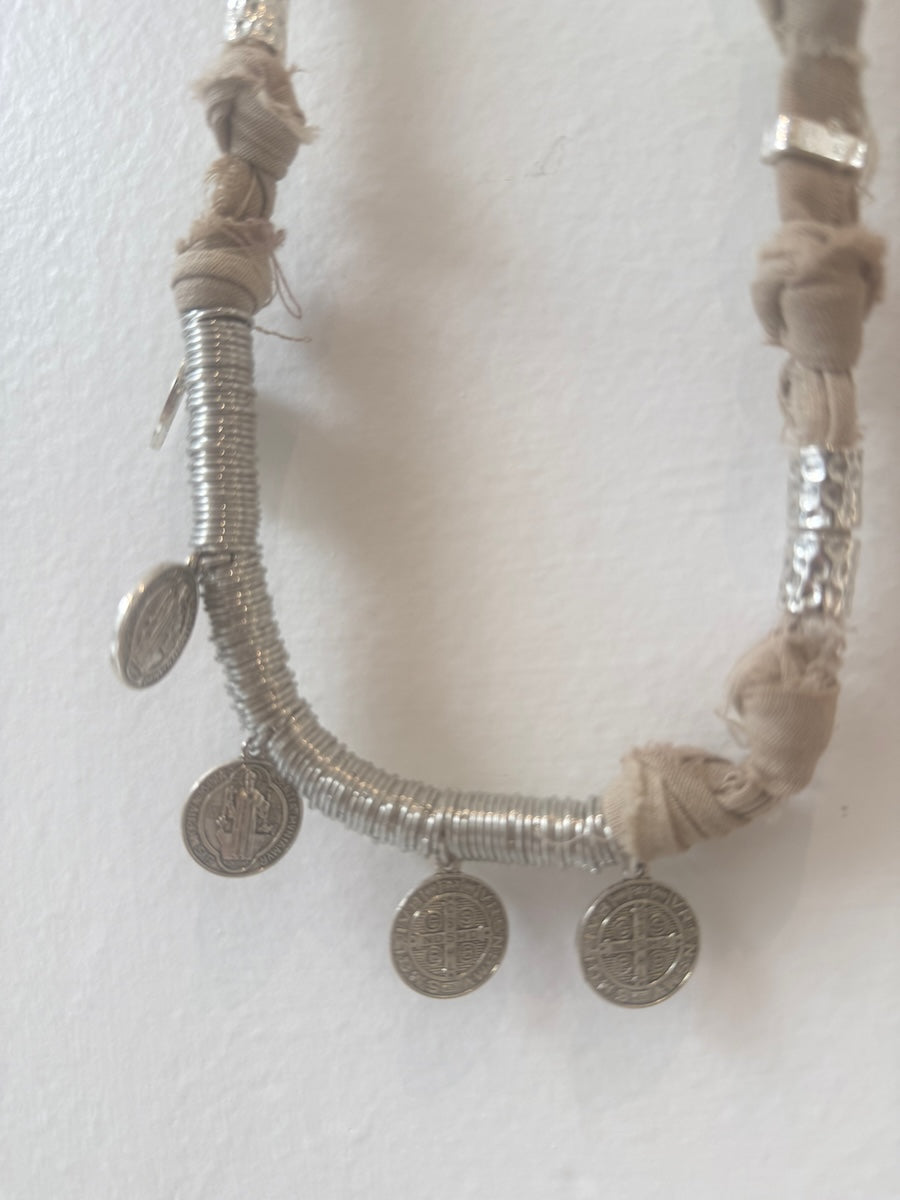 Necklace with silver coins and braided design on a white background