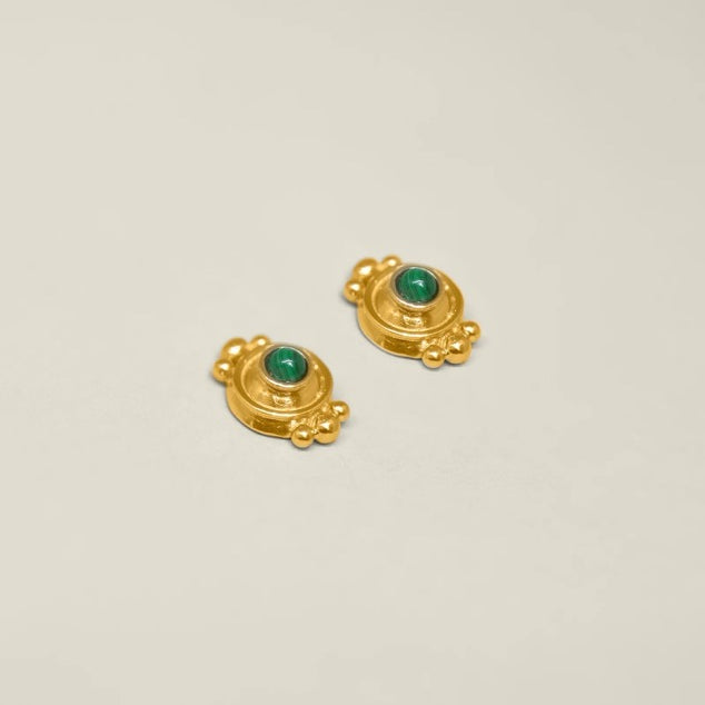 Pair of gold earrings with green gemstones on a white background.