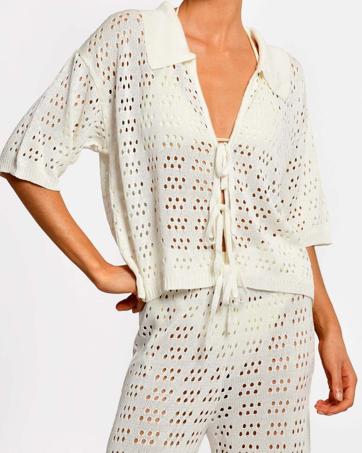 Matching white crochet top and pants on a white background.