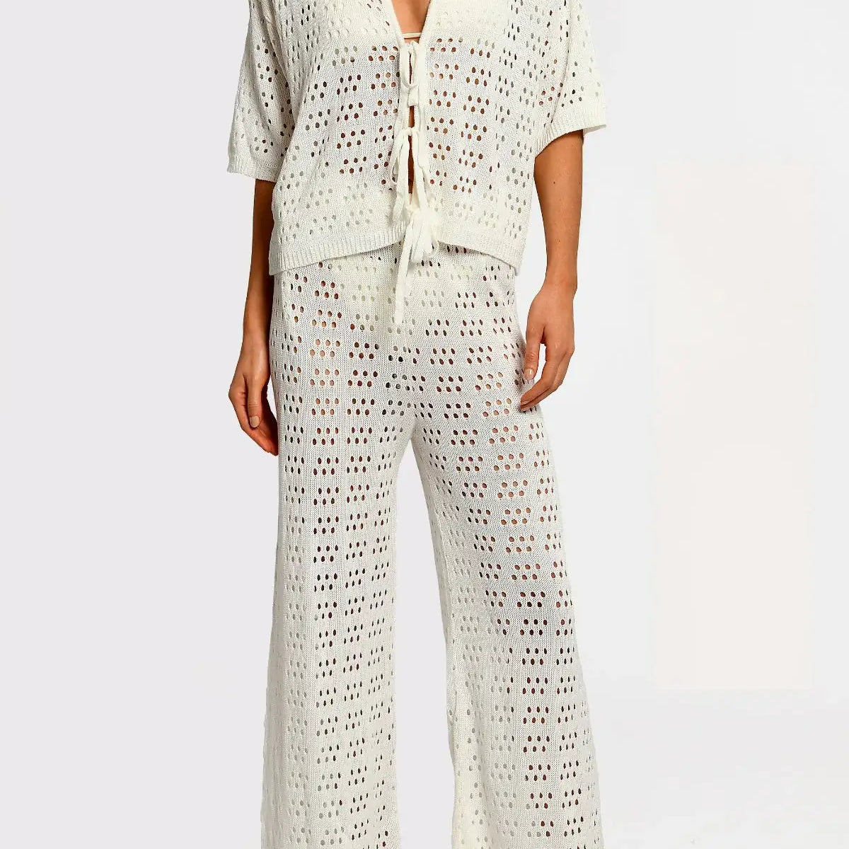 Matching white crochet top and pants on a white background.