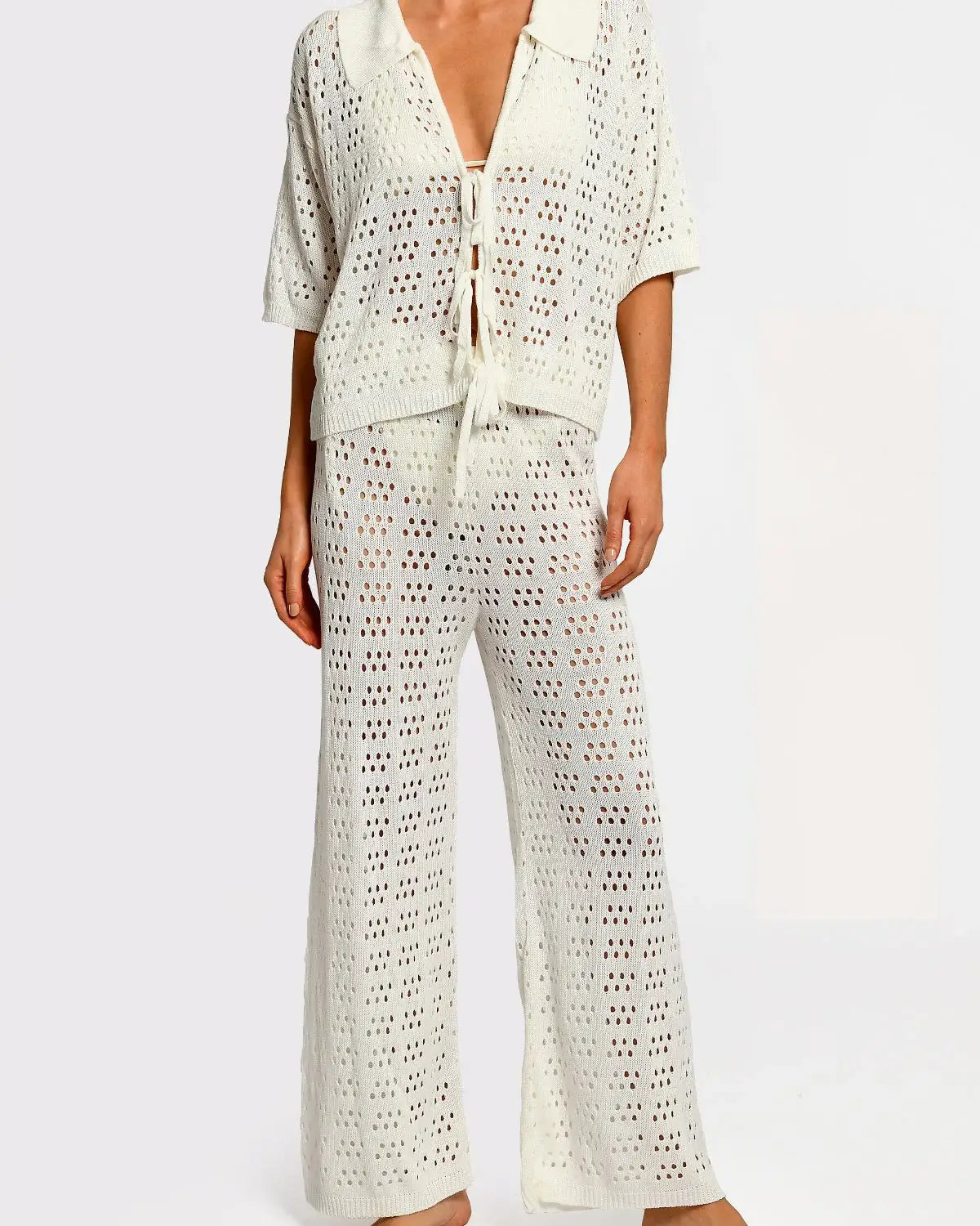 Matching white crochet top and pants on a white background.
