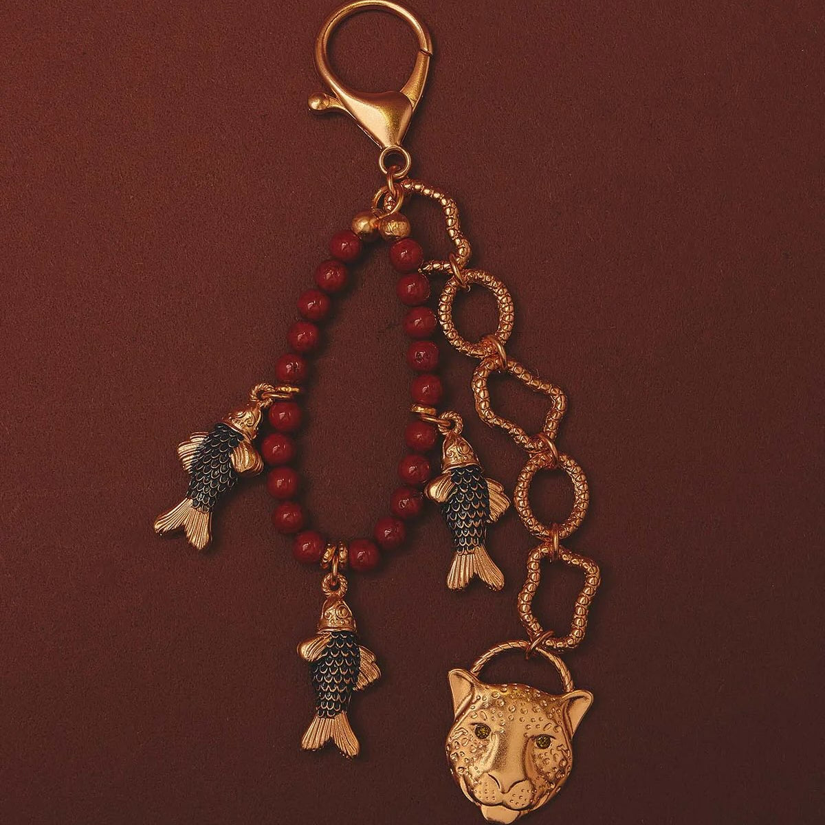 Keychain with fish and panther head charms on a red background
