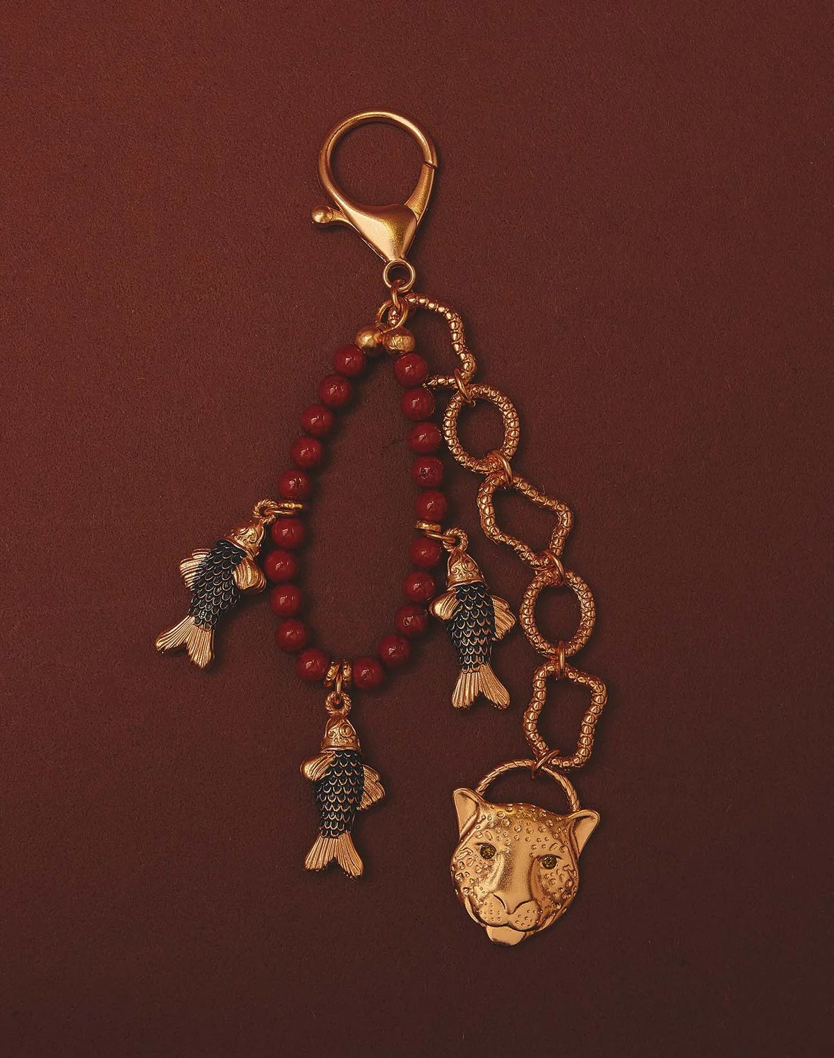 Keychain with fish and panther head charms on a red background