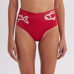 Red bikini bottom with white designs on a plain background