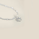 Small sterling silver horseshoe pendant with sphere detail on a neutral background