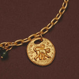 Gold necklace close-up with a monkey pendant on a brown background