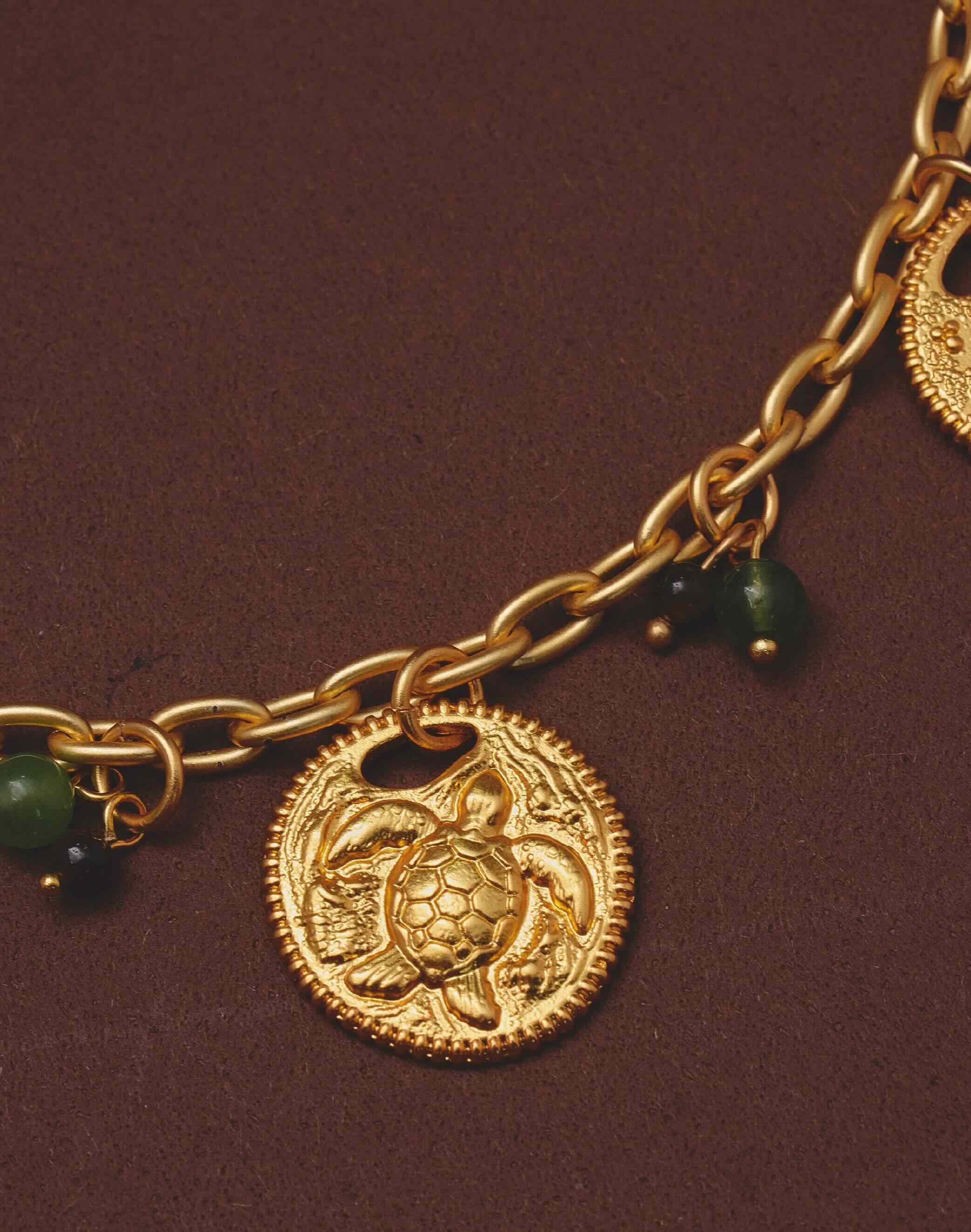 Close up of a sea turtle on a gold-plated chain necklace