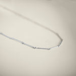 Silver necklace on a light beige background