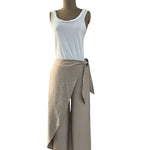 Mannequin wearing a white tank top and beige wrap skirt on a white background