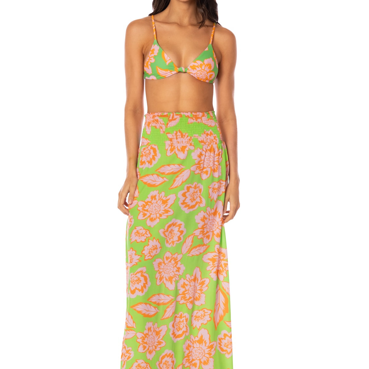 Woman wearing a floral two-piece swimsuit on a white background.