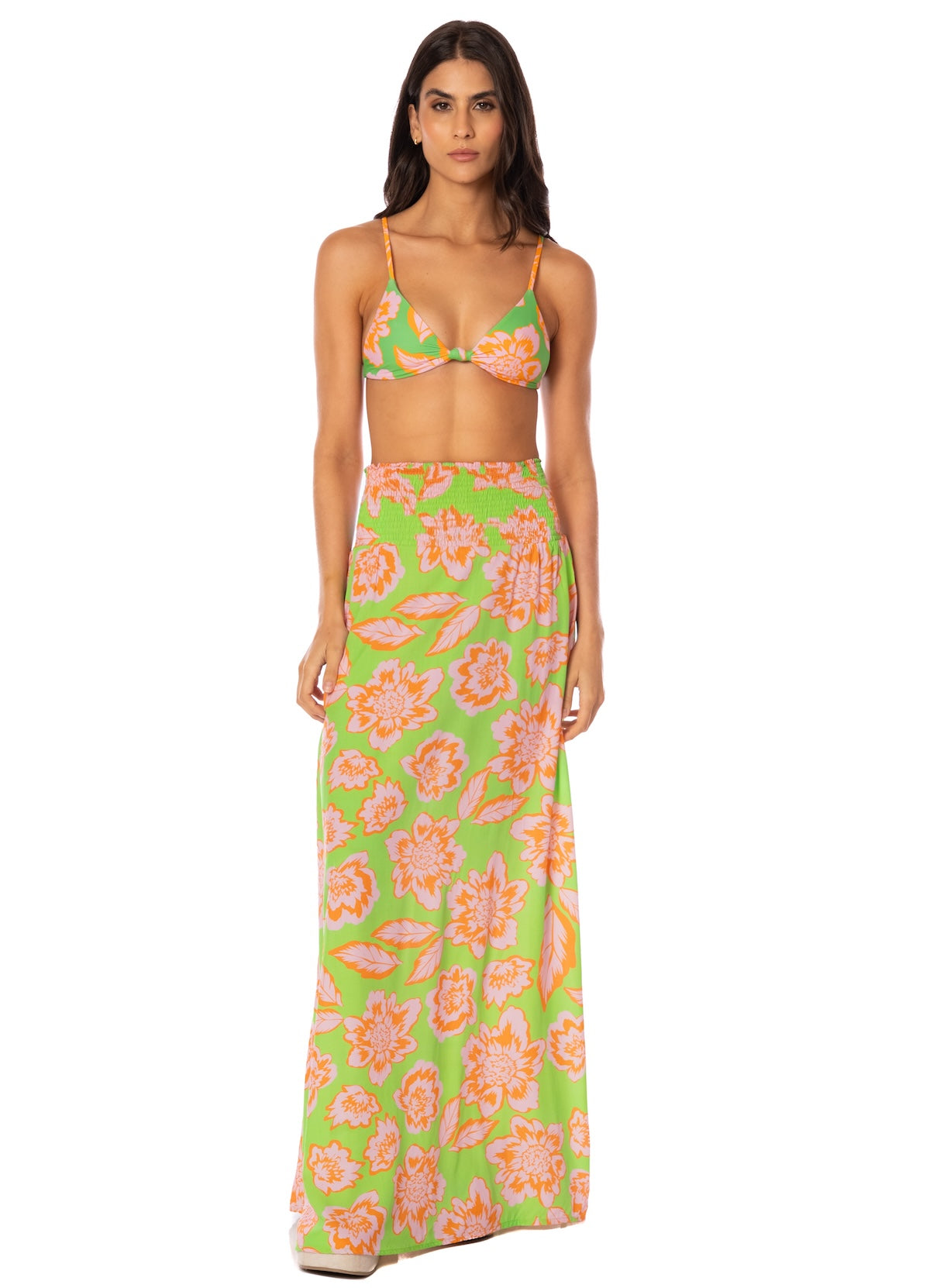 Woman wearing a floral two-piece swimsuit on a white background.