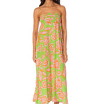 Woman wearing a strapless floral dress with a green background.