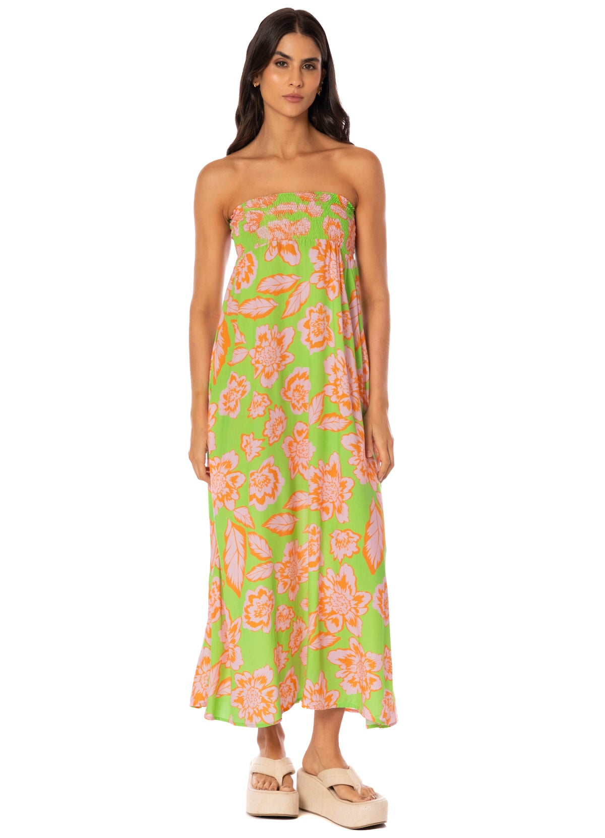 Woman wearing a strapless floral dress with a green background.