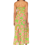 Woman wearing a strapless floral dress with a green background.