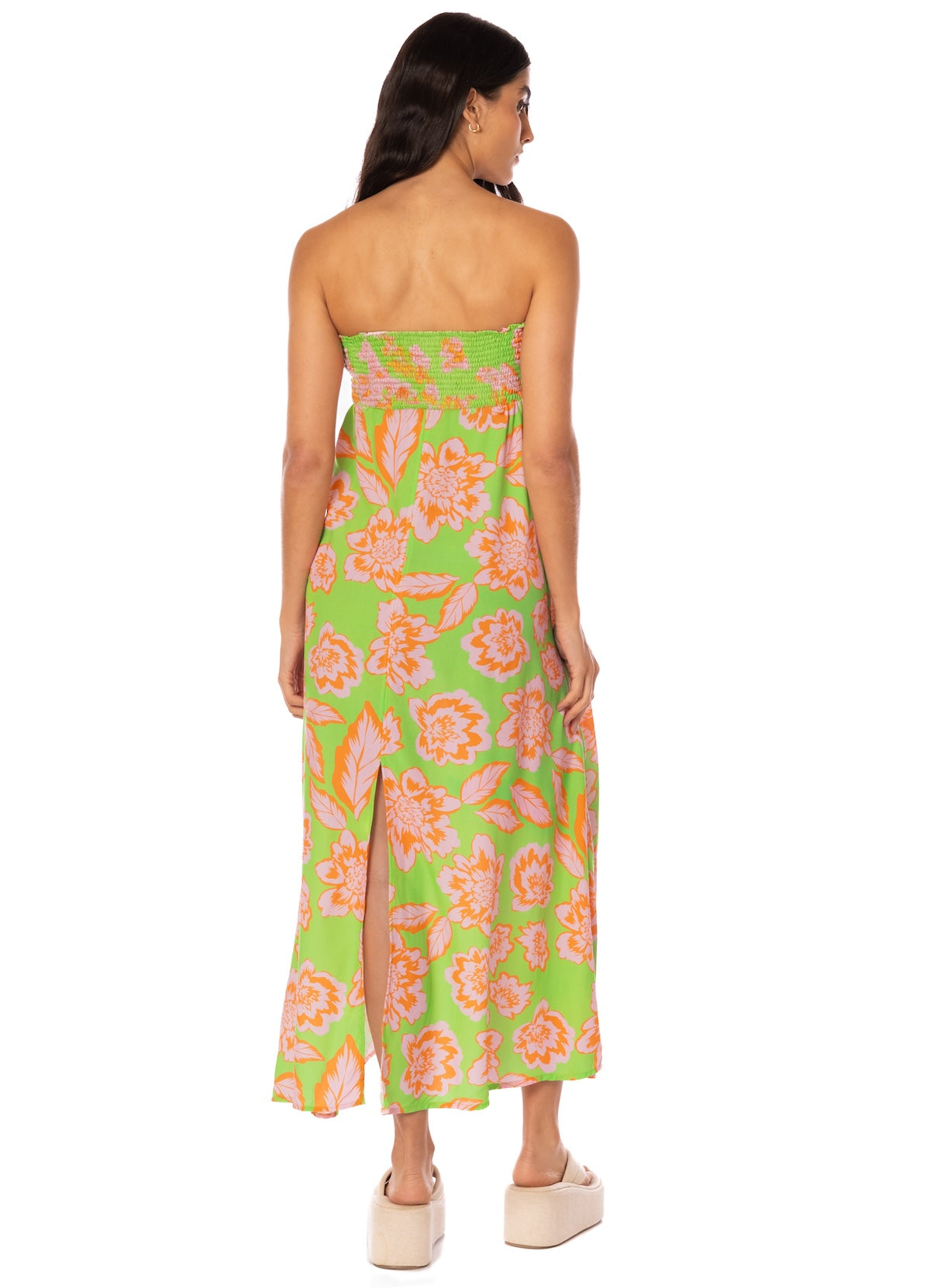 Woman wearing a strapless floral dress with a green background.