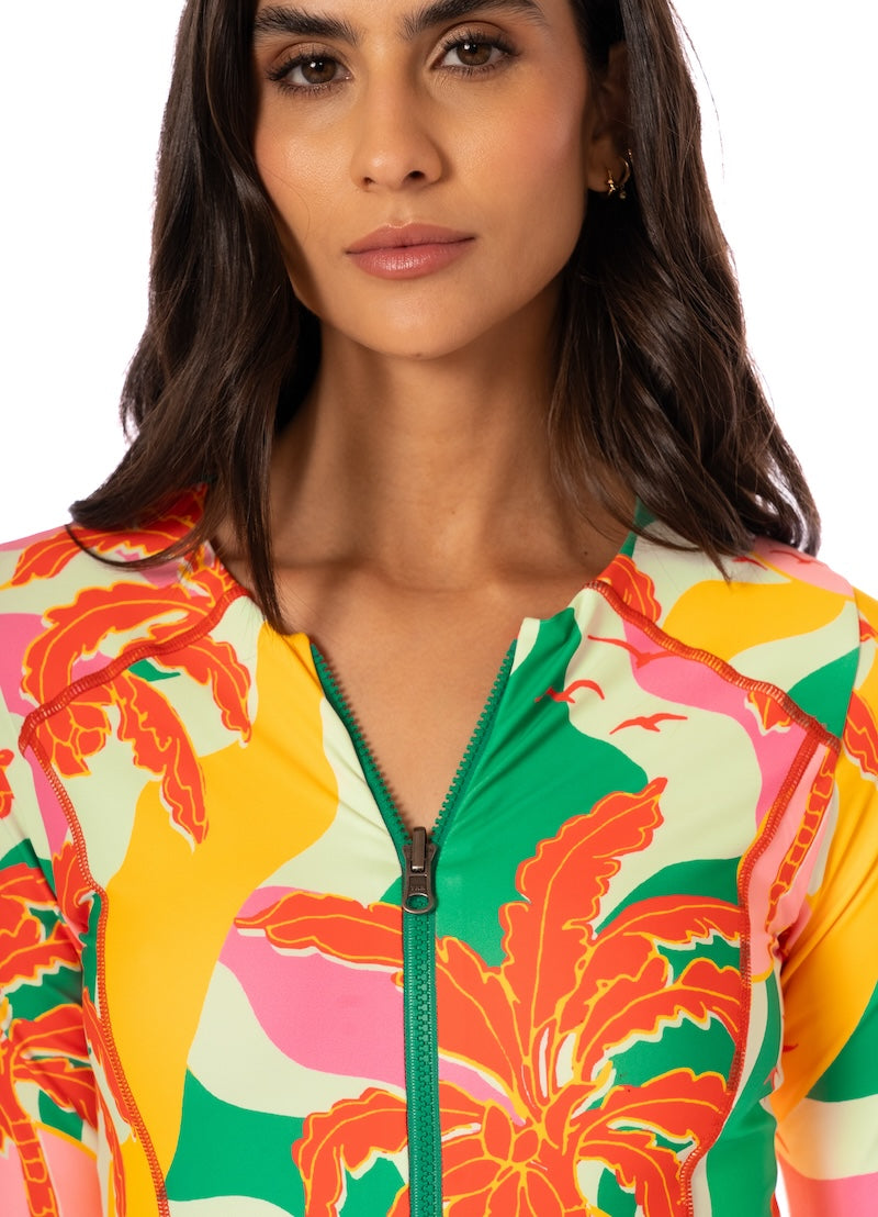 Woman wearing a colorful floral-patterned jacket with a white background.