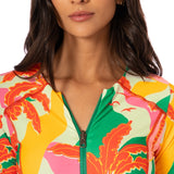 Woman wearing a colorful floral-patterned jacket with a white background.