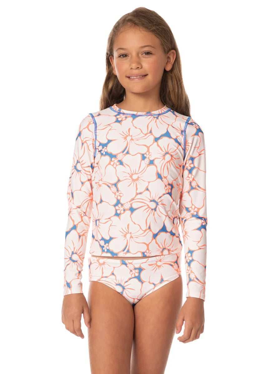 Young girl wearing a floral long-sleeve swimsuit on a white background