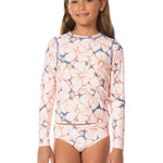 Young girl wearing a floral long-sleeve swimsuit on a white background