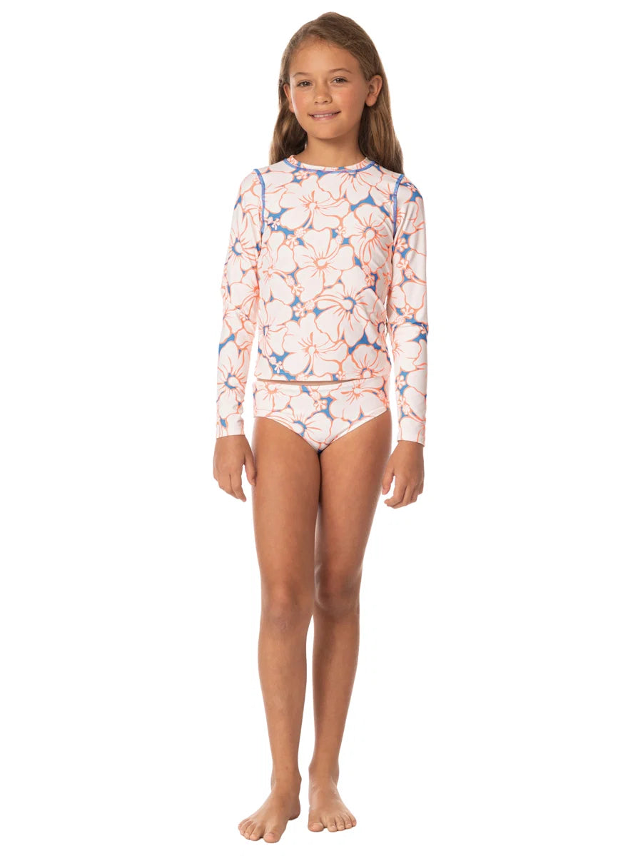 A young girl modeling a long-sleeve swim shirt and matching swim briefs with a white base and a blue and orange abstract pattern, set against a plain white background.