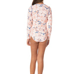 Woman wearing a floral long-sleeve swimsuit on a white background