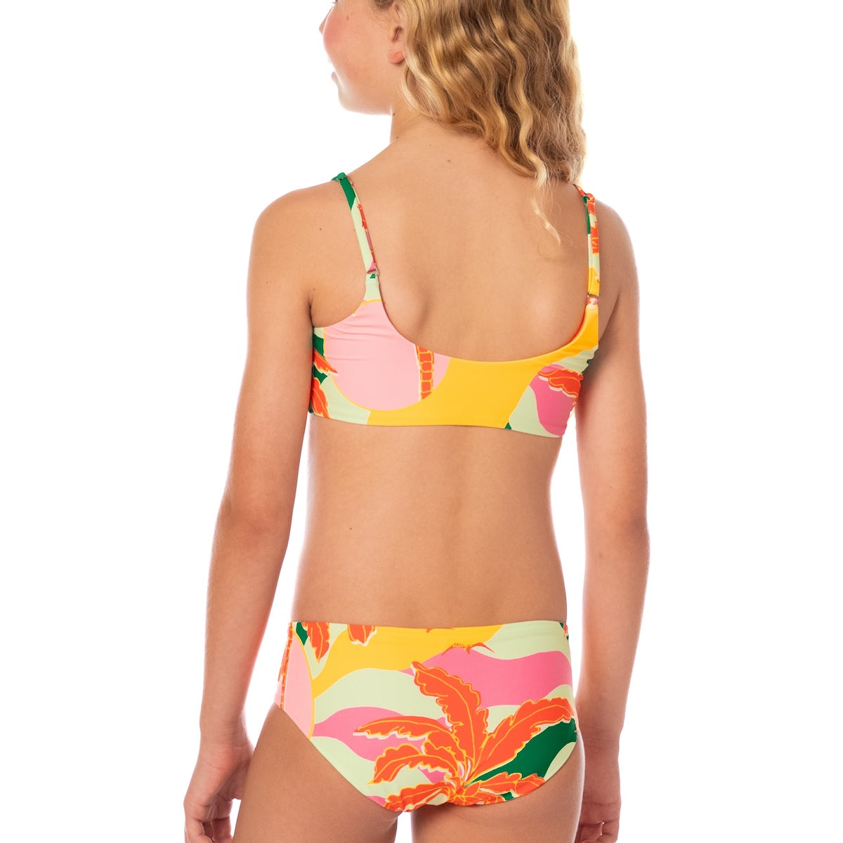 Young girl wearing a colorful floral bikini set on a white background.