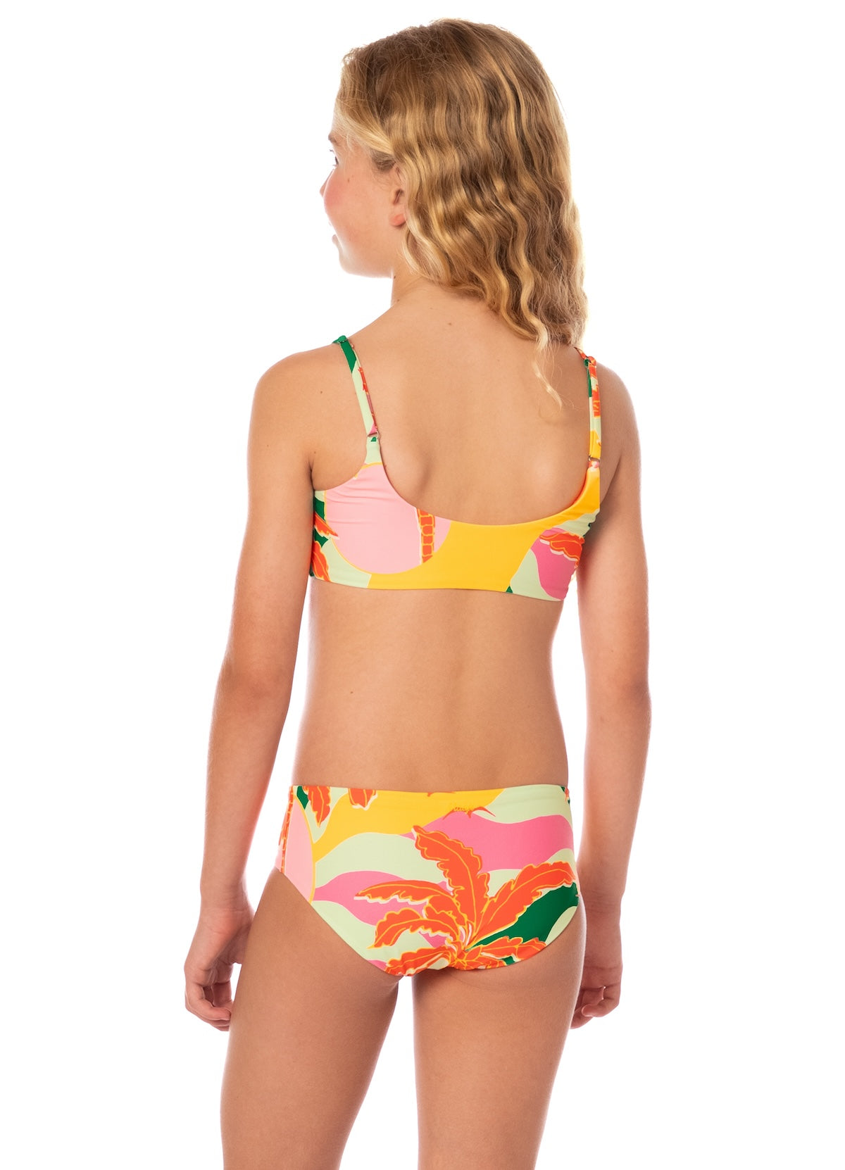 Young girl wearing a colorful floral bikini set on a white background.