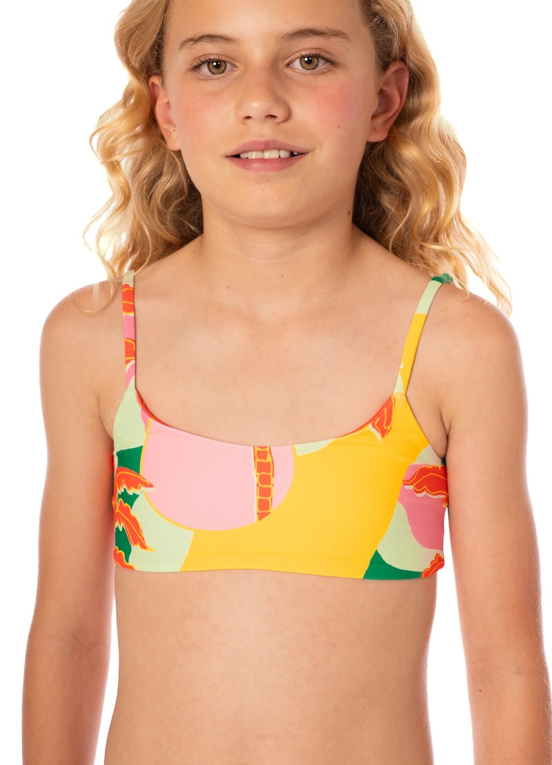 Young girl wearing a colorful bikini top with a white background
