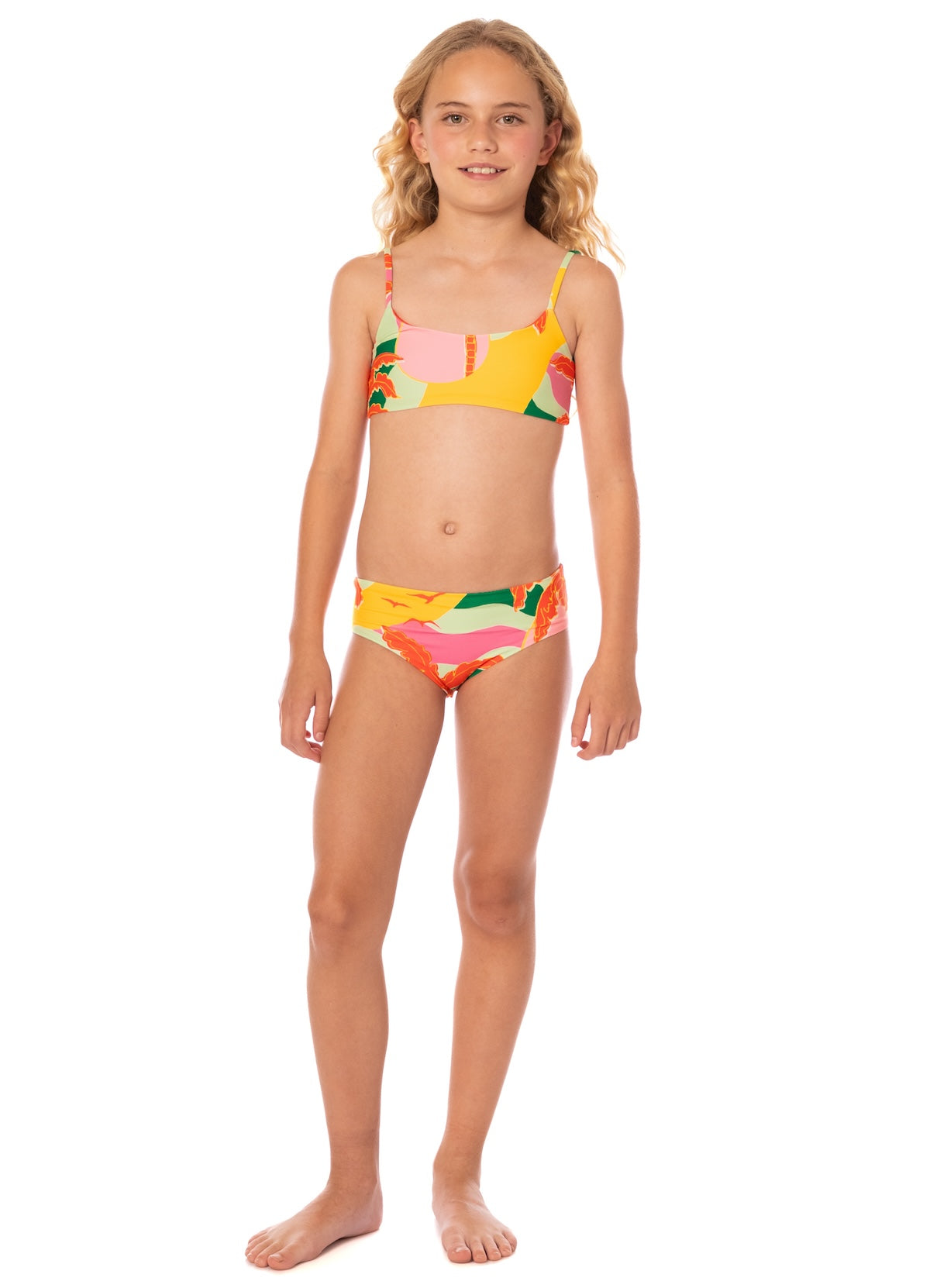 Young girl wearing a colorful bikini set on a white background.
