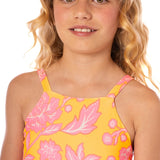 Young girl wearing a yellow floral dress with pink flowers on a white background.