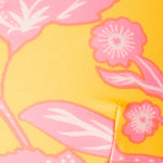 Close-up of a yellow fabric with pink floral patterns.