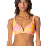 Woman wearing a colorful bikini with pink and yellow floral pattern on a white background.