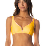 Woman wearing a yellow bikini against a white background.