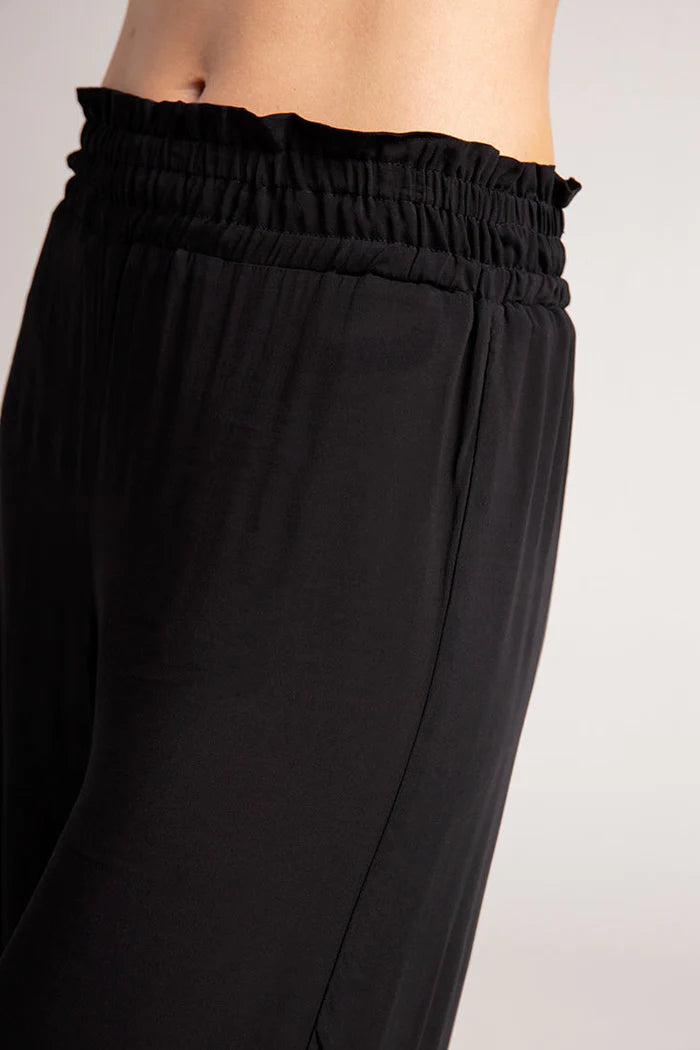 Black pants with an elastic waistband on a white background.
