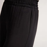 Black pants with an elastic waistband on a white background.