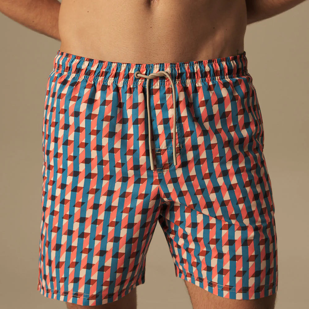 Person wearing a colorful checkered swimsuit against a neutral background.