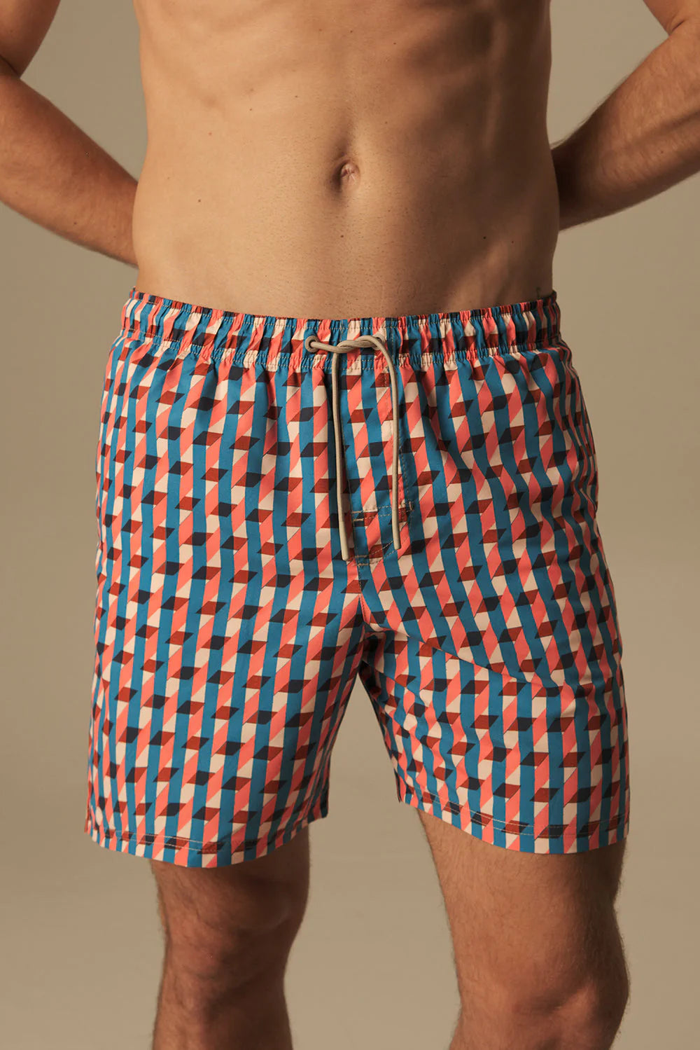 Person wearing a colorful checkered swimsuit against a neutral background.