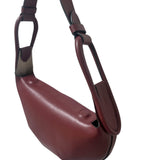 Maroon handbag with a strap on a white background.