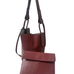 Red leather handbag with a matching pouch on a white background.