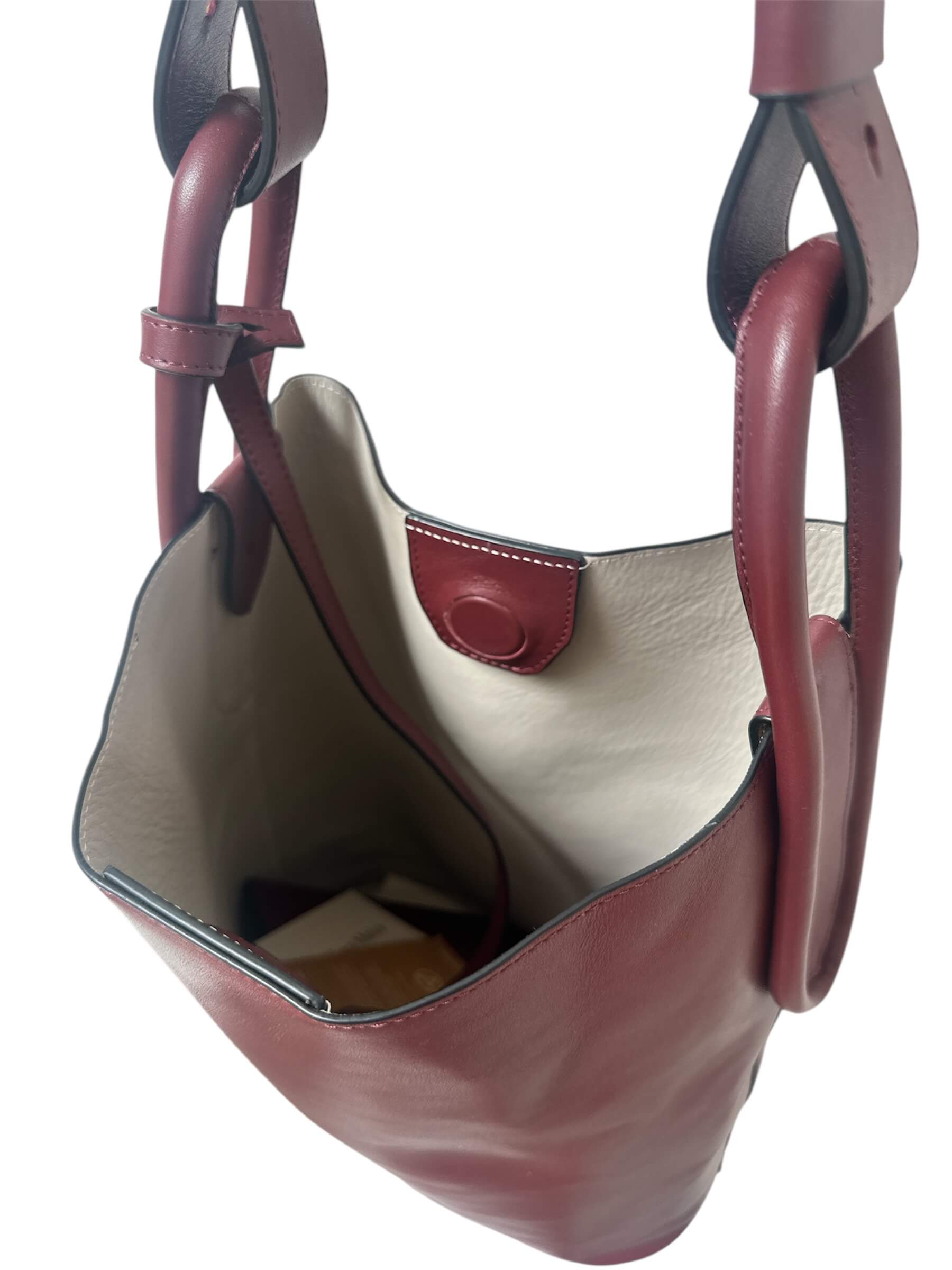 Brown leather handbag with beige interior on a white background.