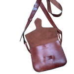 Brown leather crossbody bag with a strap on a white background.