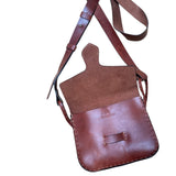 Brown leather crossbody bag with a strap on a white background.