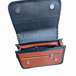 Brown and black leather crossbody carriel bag with decorative elements on a white background.