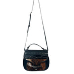 Black carriel crossbody purse with a strap and cow hide material on a white background.