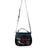 Black carriel crossbody purse with a strap and cow hide material on a white background.