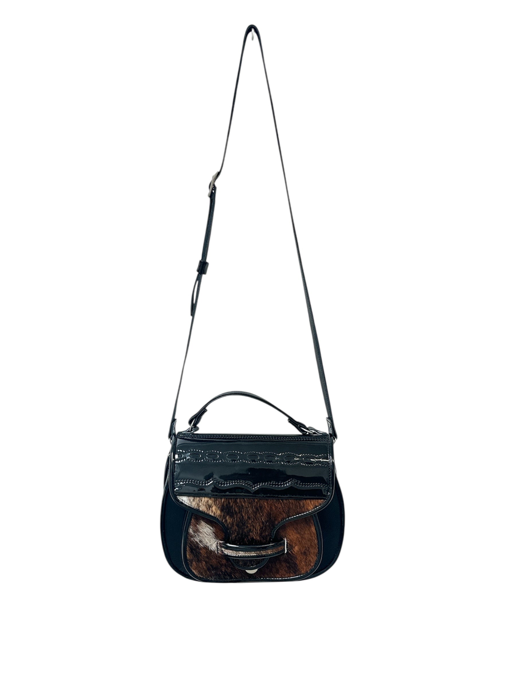 Black carriel crossbody purse with a strap and cow hide material on a white background.