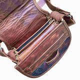 Brown leather bag with visible stitching and texture on a white background.