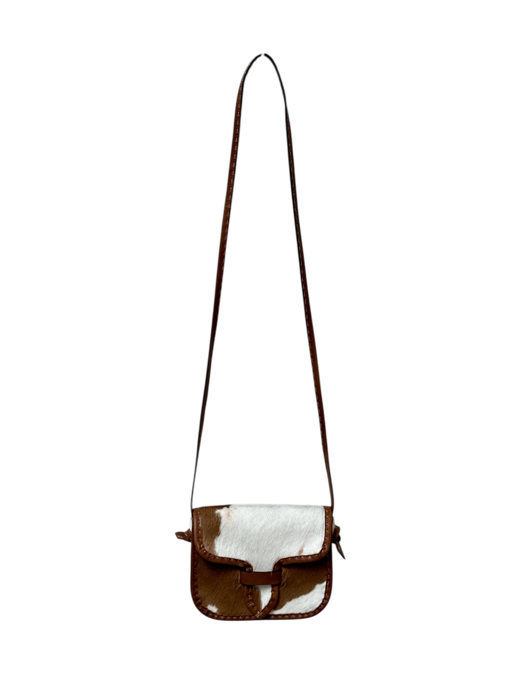 Brown and white cowhide crossbody bag on a white background