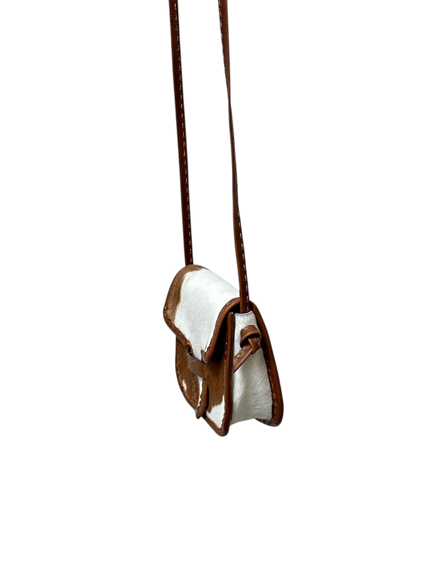 Brown and white cowhide crossbody bag on a white background.